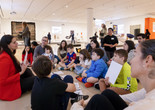 Photo: On White WallImage description: An instructor speaks to several families at the museum.