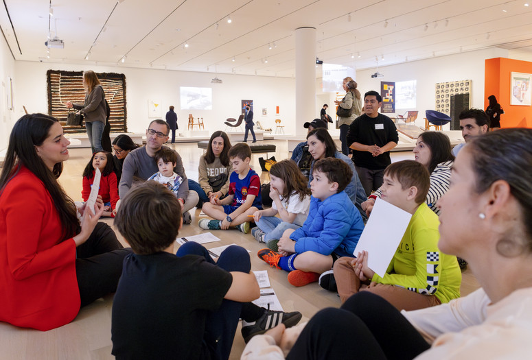 Photo: On White WallImage description: An instructor speaks to several families at the museum.