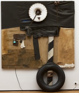 Robert Rauschenberg, <em>First Landing Jump</em> 1961. Cloth, metal, leather, electric fixture, cable, and oil paint on composition board, with automobile tire and wood plank, 7' 5 1/8" x 6' x 8 7/8" (226.3 x 182.8 x 22.5 cm). Gift of Philip Johnson