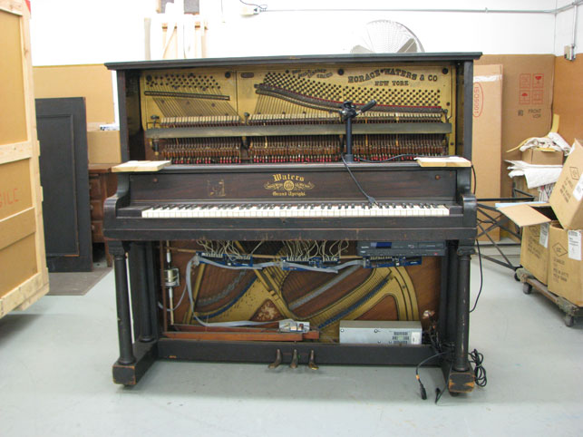 Original piano player unit and exposed circuitry under the keyboard