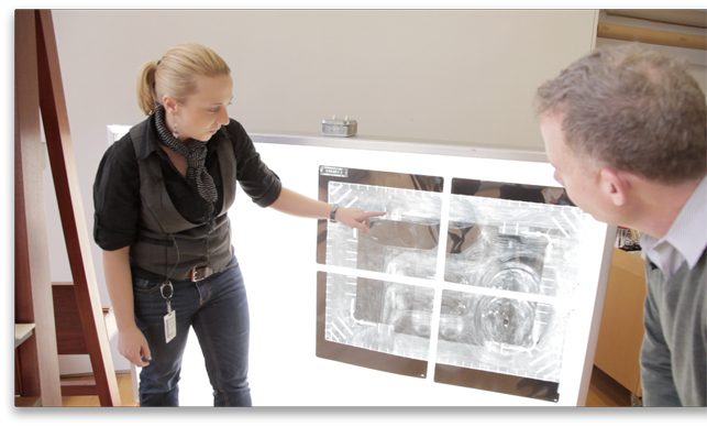 Conservators Cindy Albertson and Michael Duffy examine an x-ray of René Magritte’s The Portrait