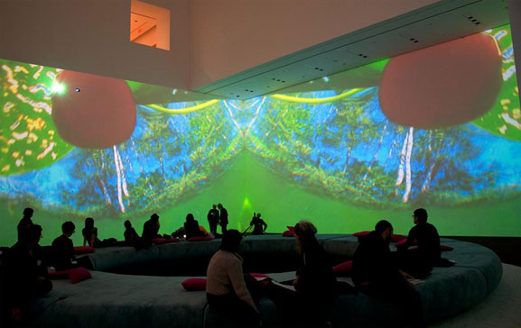 Pipilotti Rist. Pour Your Body Out (7354 Cubic Meters). 2008. Multichannel video projection (color, sound), projector enclosures, circular seating element, carpet. Installation view, The Museum of Modern Art, November 19, 2008–February 2, 2009. Courtesy the artist, Luhring Augustine, New York, and Hauser & Wirth Zürich London