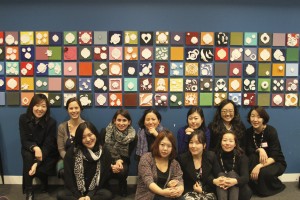 Participants in the professional exchange in front of artwork created in workshops