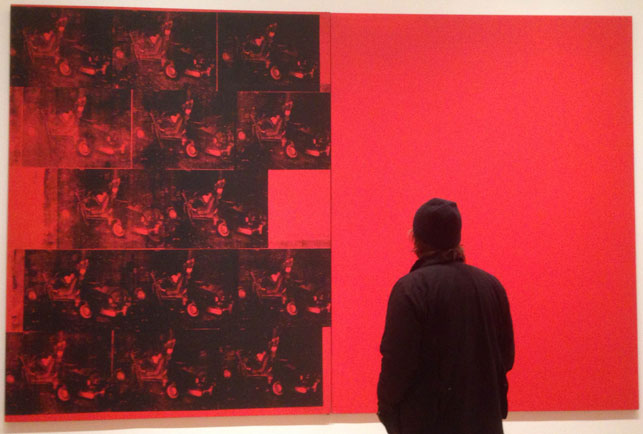 Joe Bradley examines Orange Car Crash Fourteen Times. 1963. Silkscreen ink on synthetic polymer paint on two canvases, 8' 9 7/8" x 13' 8 1/8" (268.9 x 416.9 cm). The Museum of Modern Art, New York. Gift of Philip Johnson. © 2015 Andy Warhol Foundation for the Visual Arts/Artists Rights Society (ARS), New York. Photograph by Naomi Kuromiya