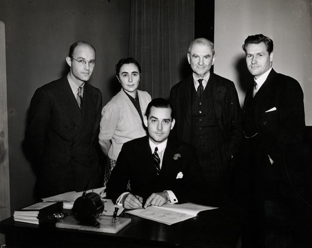 July 1935 signing of the document establishing the MoMA Film Library. From left: John Abbott, Iris Barry, John Hay Whitney (seated), A. Conger Goodyear, Nelson A. Rockefeller