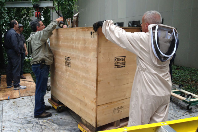 Beekeeper Andrew Cote (left) and a member of the installation team open the crate. Photo: Margaret Ewing